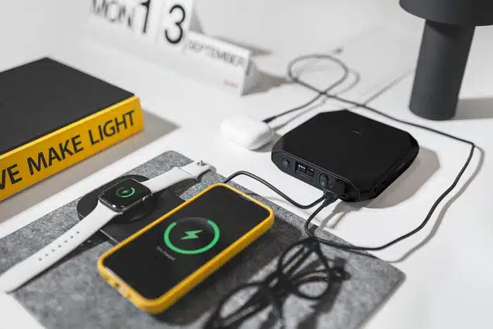 Charge sans fil d'une montre et d'un smartphone à côté d'une batterie Omni 20C+